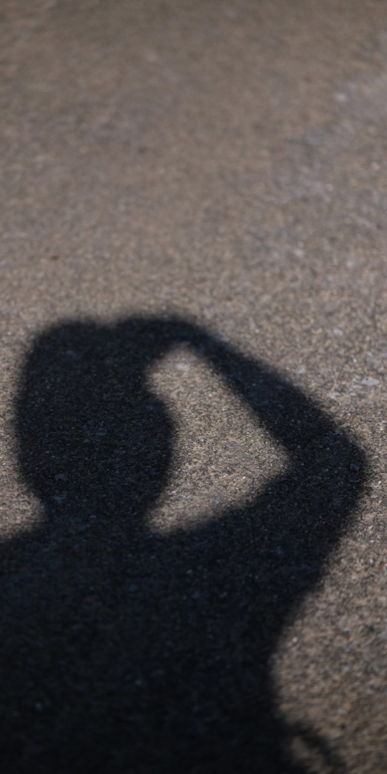 Schatten des Fotografen. Oberkörper, Kopf und angewinkelter Arm.